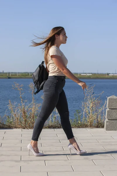 Portrait of young european woman is standing near the lake, beautiful european woman in nature.