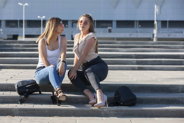 Two sexy girls sitting on a stairs. Outdoor fashion portrait — Stock Photo, Image