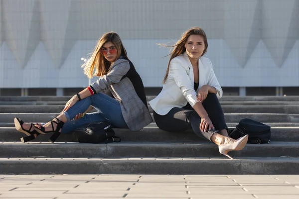 Şehirdeki güzel kızlar. Merdivenlerde oturan şık bayanlar — Stok fotoğraf