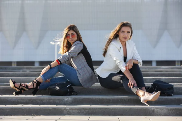 Mooie meiden in een stad. Stijlvolle dames zittend op een trap — Stockfoto