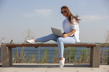 Halka açık bir parkta dizüstü bilgisayarla bir şey üzerinde çalışmak