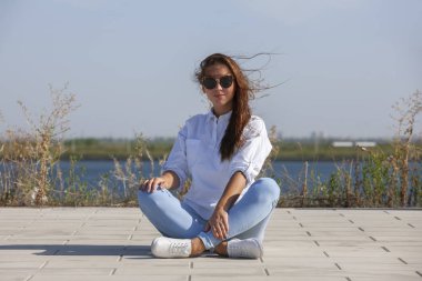 Park zeminde oturan düşünceli genç kadın