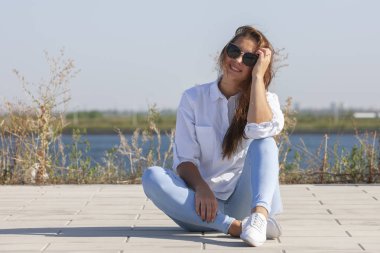 Park zeminde oturan düşünceli genç kadın