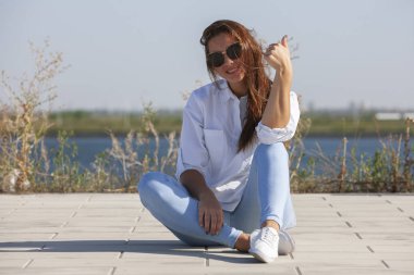 Park zeminde oturan düşünceli genç kadın