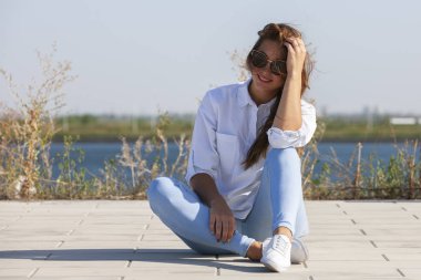 Park zeminde oturan düşünceli genç kadın