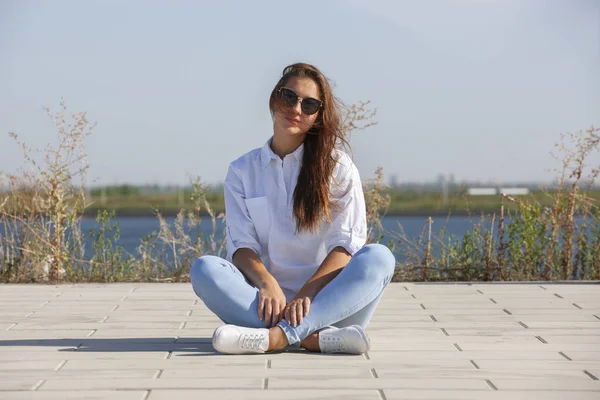 Ragazza premurosa seduta a terra nel parco — Foto Stock