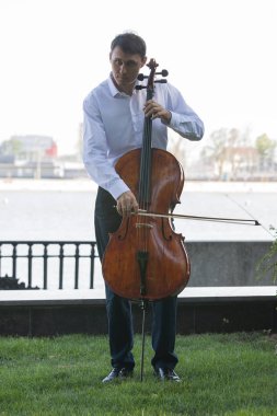 Müzisyenler güneş ışığıyla çello çalıyorlar.