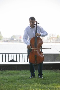 Müzisyenler güneş ışığıyla çello çalıyorlar.