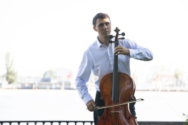 Müzisyenler güneş ışığıyla çello çalıyorlar.