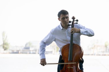 Müzisyenler güneş ışığıyla çello çalıyorlar.