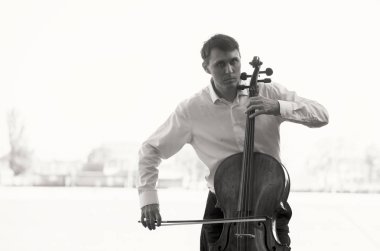 Müzisyenler güneş ışığıyla çello çalıyorlar.