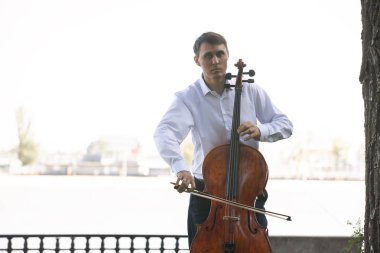 Müzisyenler güneş ışığıyla çello çalıyorlar.