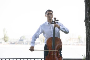 Müzisyenler güneş ışığıyla çello çalıyorlar.