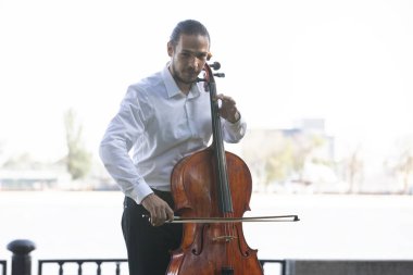 Müzisyenler güneş ışığıyla çello çalıyorlar.