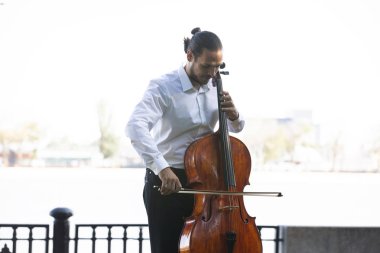 Müzisyenler güneş ışığıyla çello çalıyorlar.