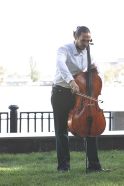 Müzisyenler güneş ışığıyla çello çalıyorlar.