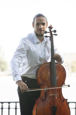 Müzisyenler güneş ışığıyla çello çalıyorlar.