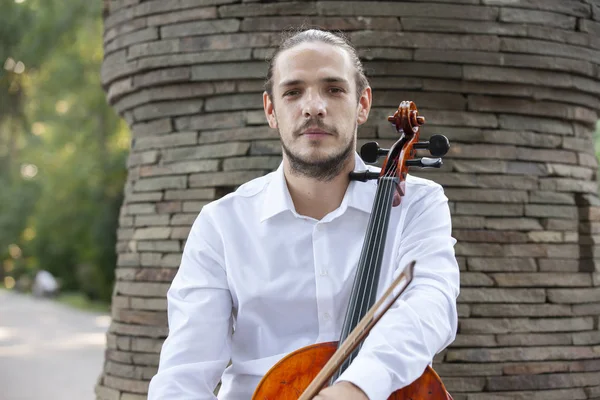 Genç adam dışarıda oynarken çello. Klasik müzik Çello çalan çellist