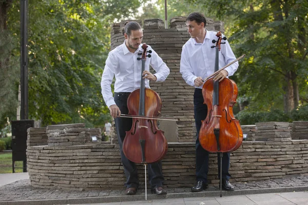 çellist müzisyen grubu sokakta müzik gerçekleştirmek, Keman çalmaya erkek ol kapatın