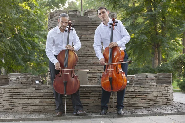 Cellist musiker grupp utför musik i gatan, på nära håll man spelar fiol — Stockfoto