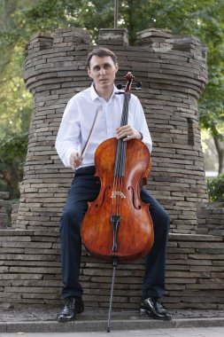 Genç adam dışarıda oynarken çello. Klasik müzik Çello çalan çellist