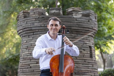 Genç adam dışarıda oynarken çello. Klasik müzik Çello çalan çellist