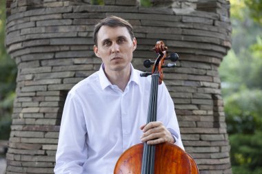 Genç adam dışarıda oynarken çello. Klasik müzik Çello çalan çellist