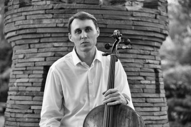 Genç adam dışarıda oynarken çello. Klasik müzik Çello çalan çellist