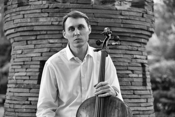 Genç adam dışarıda oynarken çello. Klasik müzik Çello çalan çellist