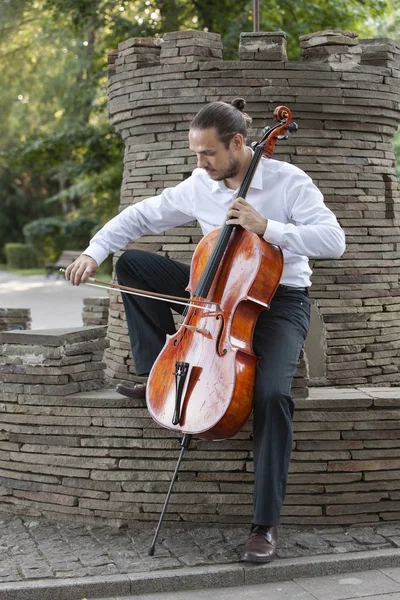 Genç adam dışarıda oynarken çello. Klasik müzik Çello çalan çellist