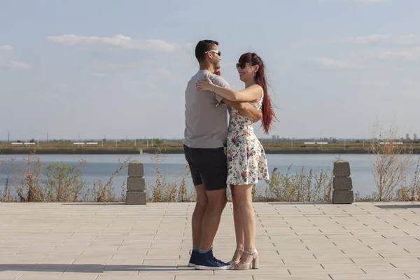 Mutlu sevgi dolu çift kucaklayan ve mavi gökyüzü altında yaz aylarında açık havada öpüşme. Aşk hikayesi. Aşık bir çift. Deniz arka planı. Balayı, seyahat, turizm. Moda fotoğrafı. Deniz kumu. Mutlu günler.