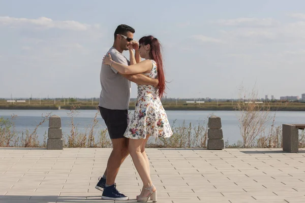 Mutlu sevgi dolu çift kucaklayan ve mavi gökyüzü altında yaz aylarında açık havada öpüşme. Aşk hikayesi. Aşık bir çift. Deniz arka planı. Balayı, seyahat, turizm. Moda fotoğrafı. Deniz kumu. Mutlu günler.