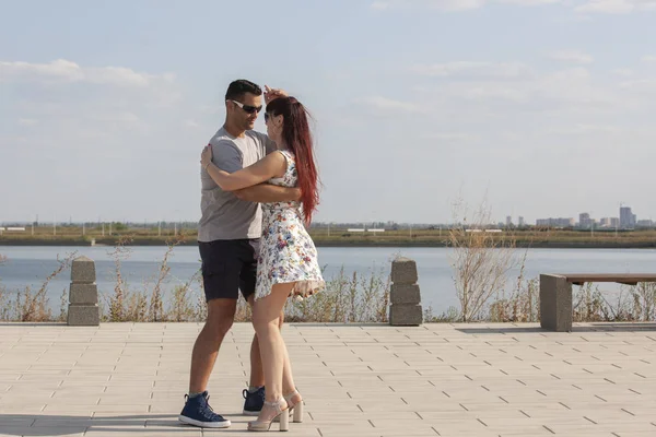 Mutlu sevgi dolu çift kucaklayan ve mavi gökyüzü altında yaz aylarında açık havada öpüşme. Aşk hikayesi. Aşık bir çift. Deniz arka planı. Balayı, seyahat, turizm. Moda fotoğrafı. Deniz kumu. Mutlu günler.