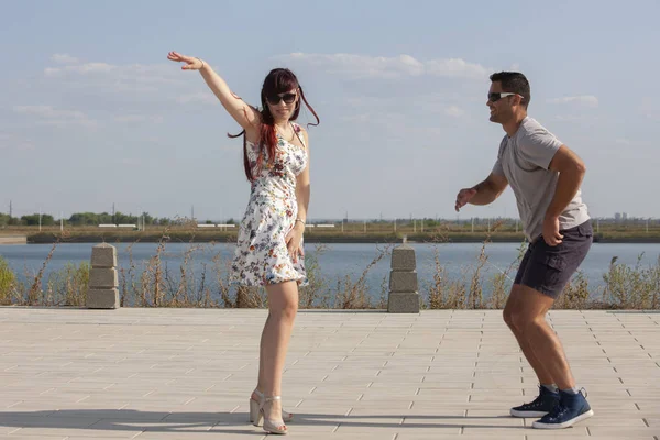 Mutlu sevgi dolu çift kucaklayan ve mavi gökyüzü altında yaz aylarında açık havada öpüşme. Aşk hikayesi. Aşık bir çift. Deniz arka planı. Balayı, seyahat, turizm. Moda fotoğrafı. Deniz kumu. Mutlu günler.