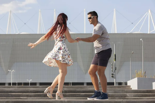 Casal jovem dançando dança latina contra paisagem urbana . — Fotografia de Stock
