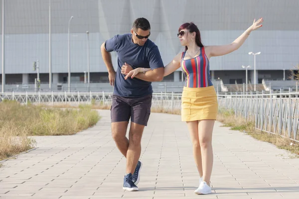 Casal jovem dançando dança latina contra paisagem urbana . — Fotografia de Stock