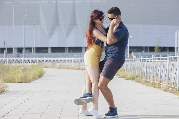 Couple dancing at sunset salsa brazilian zouk. Lovers, dance partners spinning, latin festival dance concept.