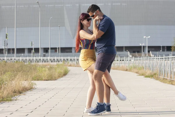 Casal jovem dançando dança latina contra paisagem urbana . — Fotografia de Stock