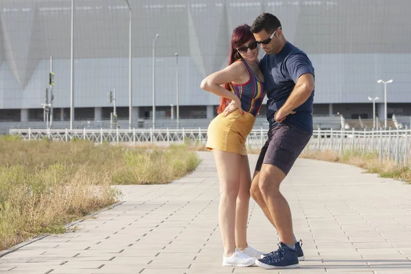 Casal jovem dançando dança latina contra paisagem urbana . — Fotografia de Stock