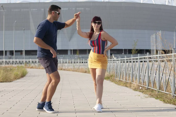 Casal jovem dançando dança latina contra paisagem urbana . — Fotografia de Stock