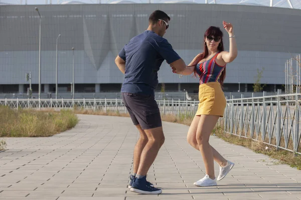 Casal jovem dançando dança latina contra paisagem urbana . — Fotografia de Stock