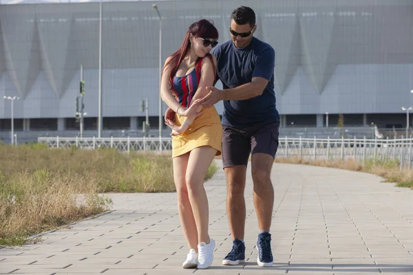 Casal jovem dançando dança latina contra paisagem urbana . — Fotografia de Stock