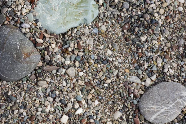 Steine Textur. Hintergrund die feuchten mehrfarbigen Kieselsteine Nahaufnahme weichen Fokus vom Kieselstrand bei trübem Wetter. — Stockfoto