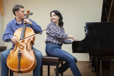 Senfoni orkestrasının müzisyenleri. Çellocu ve piyanist
