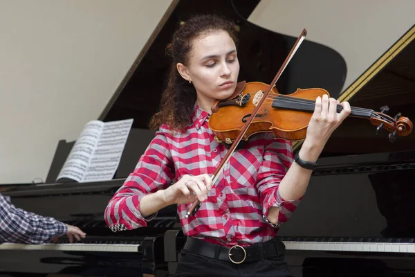 Flicka som spelar fiol. ung kvinna studerar musik ensam hemma. — Stockfoto