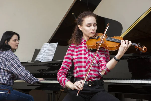 Flicka som spelar fiol. ung kvinna studerar musik ensam hemma. — Stockfoto