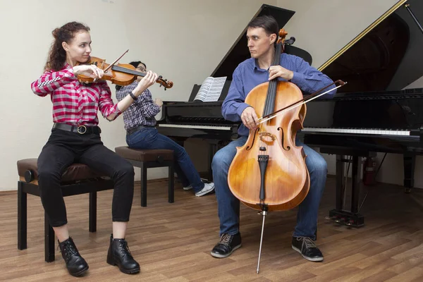 Prove del trio di famiglia. Papà suona il violoncello, la figlia è una violinista, la madre suona il pianoforte — Foto Stock