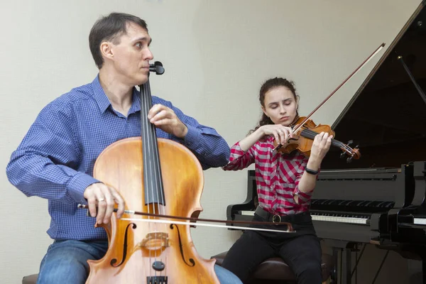 Symfoniorkesterns musiker. Ung violinist och cellist i konsertdräkter. — Stockfoto