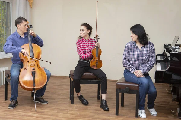 Prove del trio di famiglia. Papà suona il violoncello, la figlia è una violinista, la madre suona il pianoforte — Foto Stock