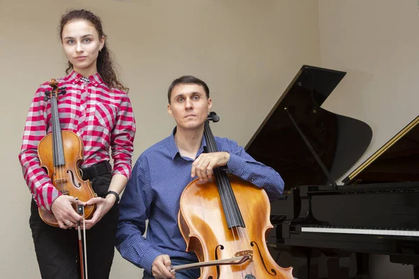 Muzikanten van het symfonieorkest. Jonge violist en cellist in concertkostuums. — Stockfoto